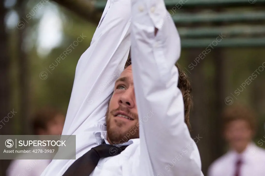 Businessman at an obstacle course dangling from parallel bars