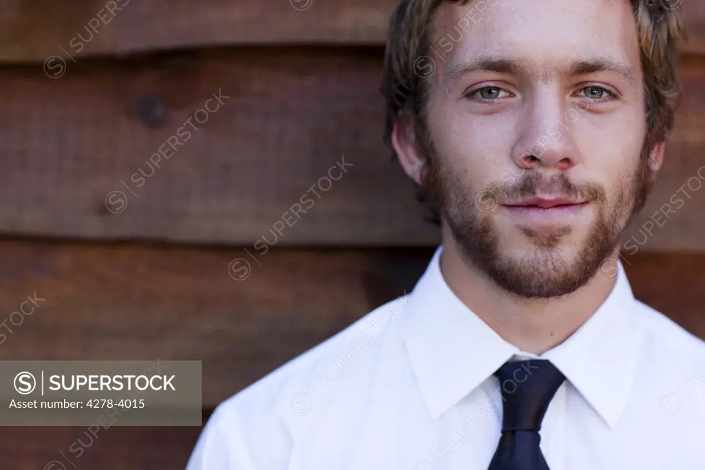 Businessman standing against a wood wall