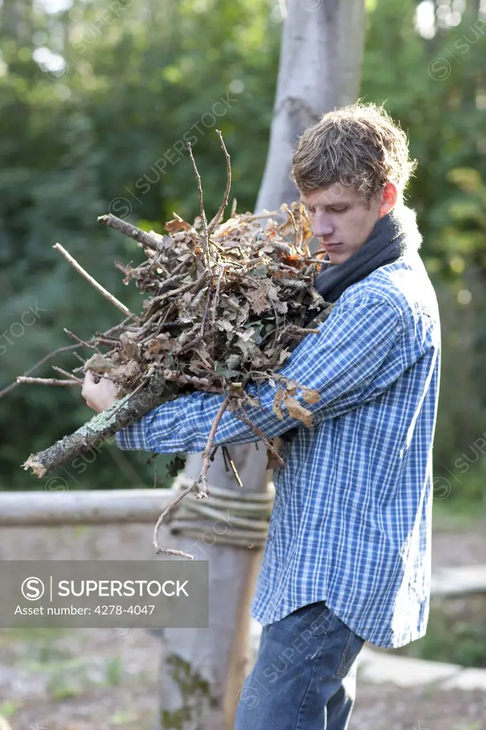 Young man carrying firewood