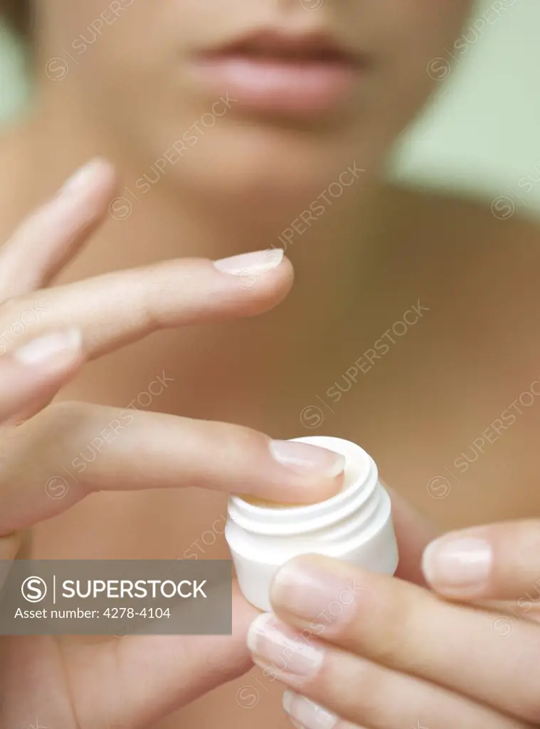 Close up of a young woman hands holding a  cream jar