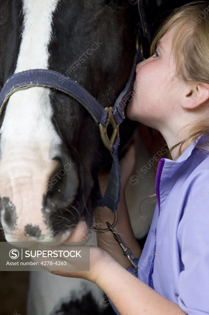 Young girl kissing a horse head