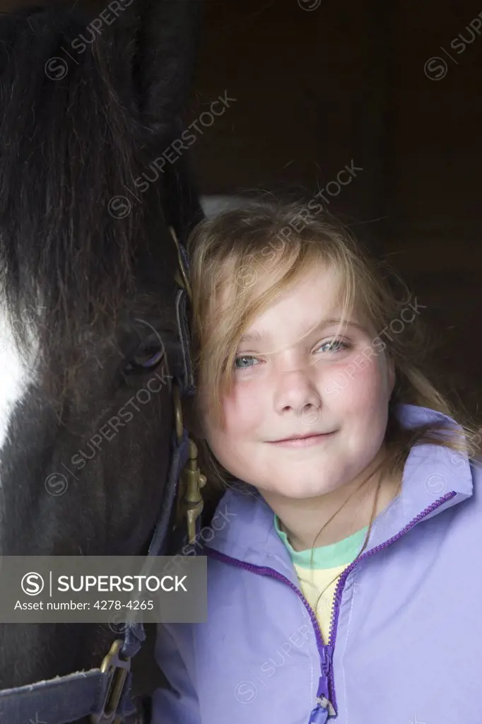 Young girl hugging a horse head