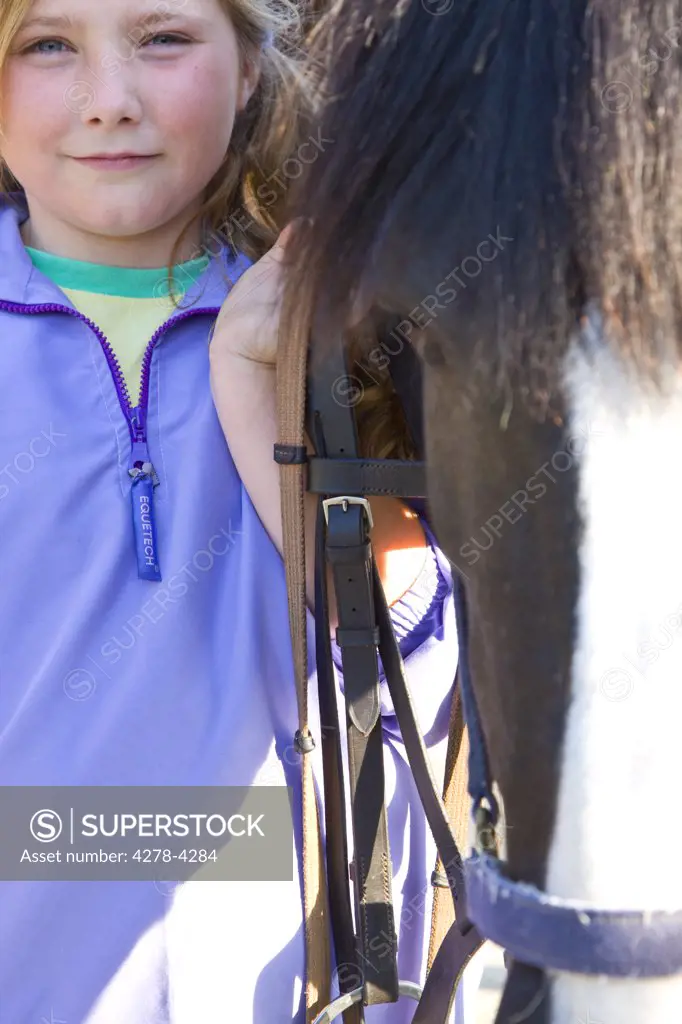 Young girl standing next to a horse