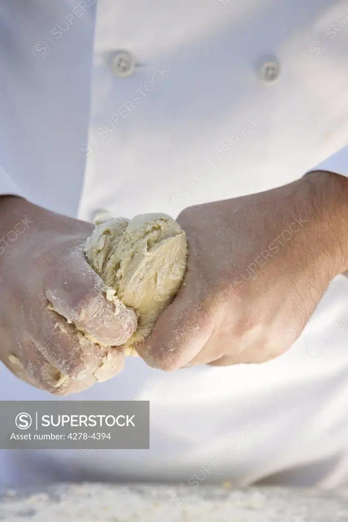 Close up of a chef hands kneading pastry dough