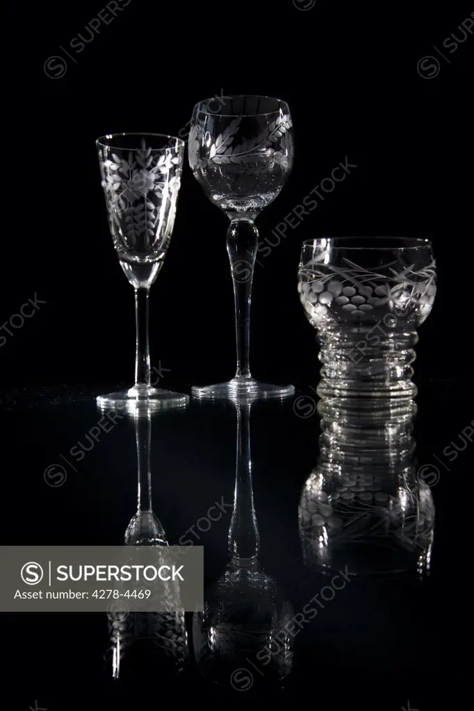 Three empty crystal glasses on a glass surface