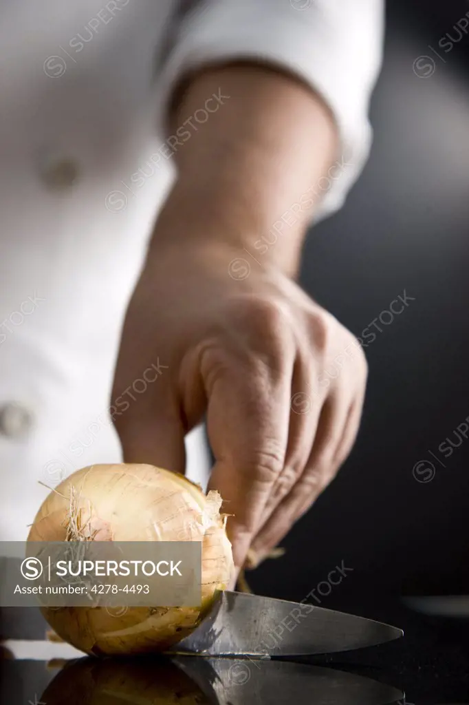 Close up of a chef hand cutting an onion