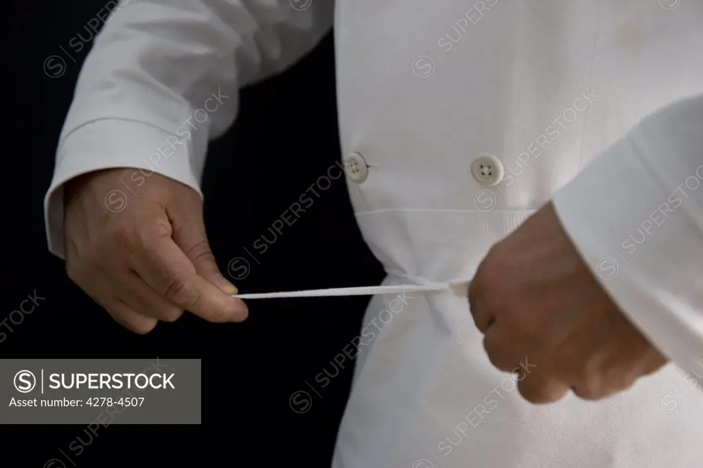 Close up of a chef hands fastening his apron