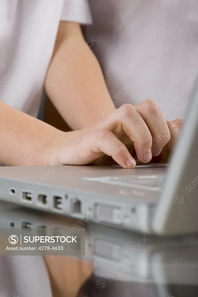 Close up of a boy hands typing on a laptop computer