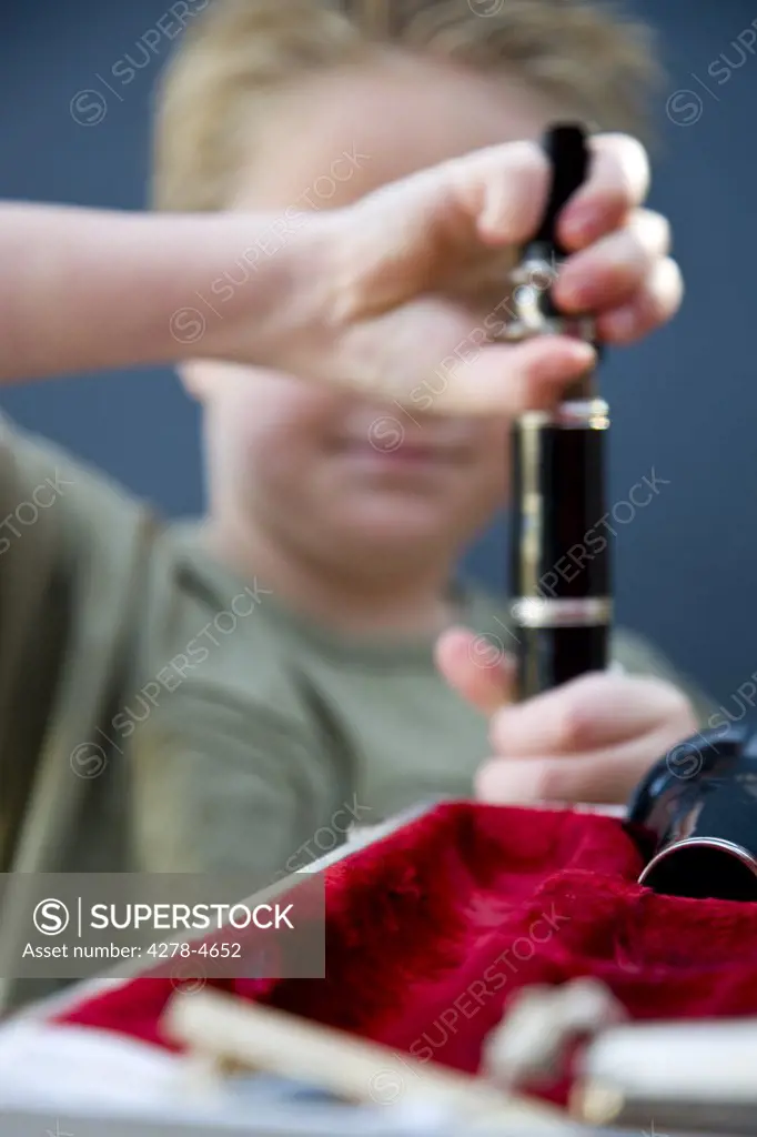 Close up of a boy hands putting together a clarinet