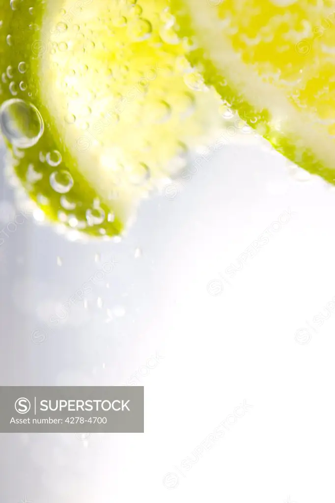 Extreme close up of slices of lime floating in sparkling water