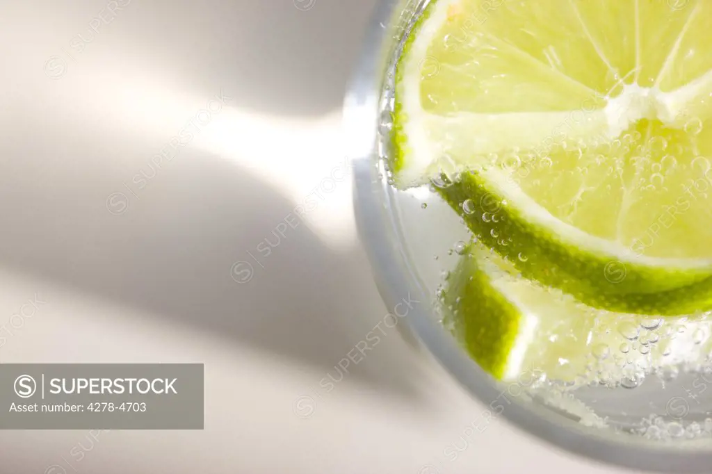 Extreme close up of a glass of sparkling water with sliced lime - high angle