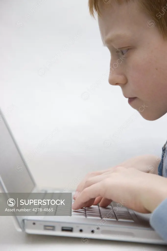 Close up of a boy using a laptop computer