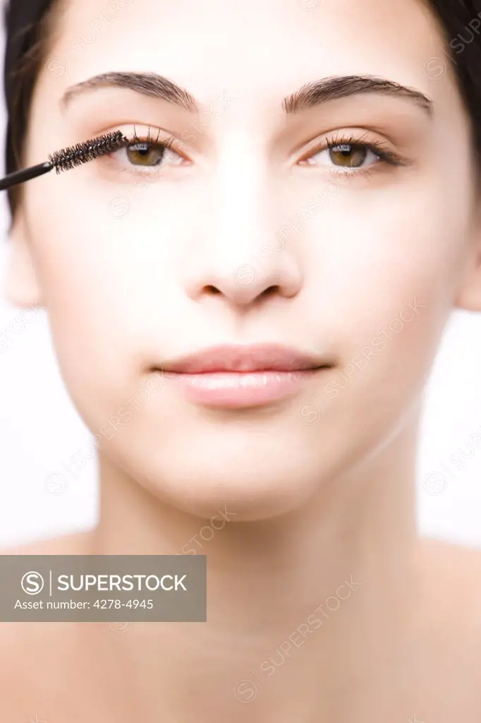 Close up of a young woman applying mascara