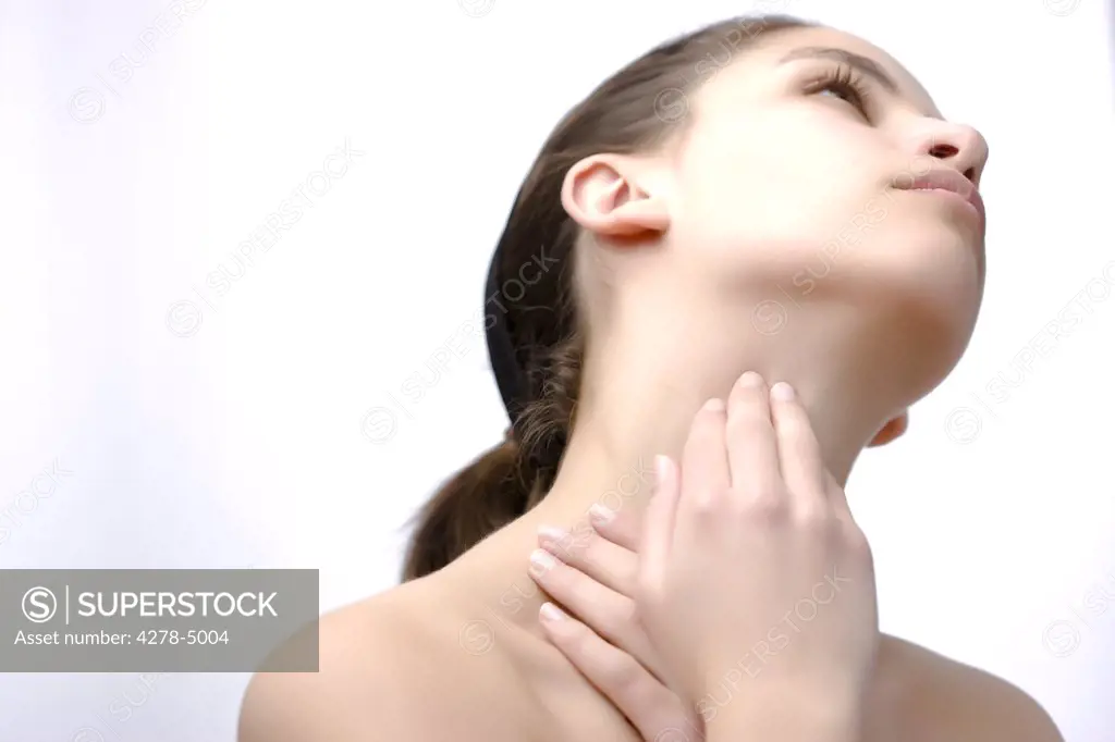 Woman with her head tilted back touching her neck