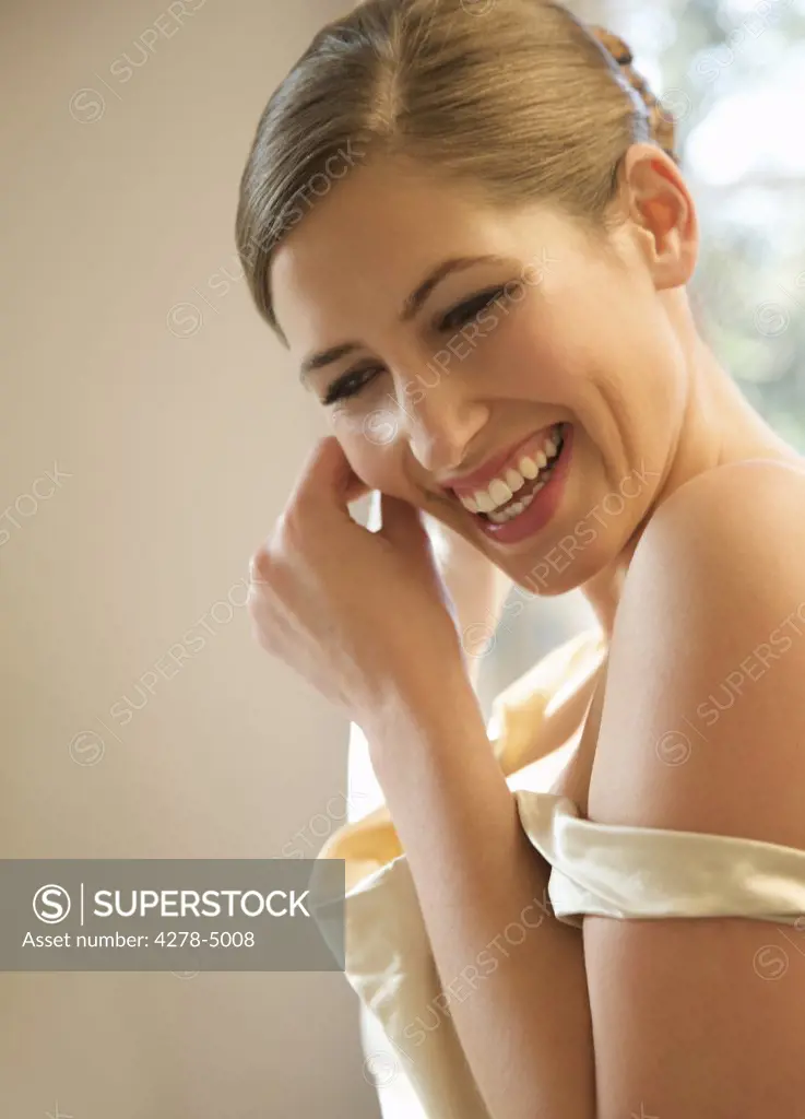 Smiling bride adjusting her earrings