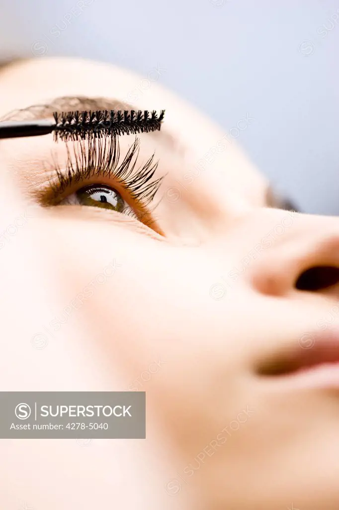 Extreme close up of a woman applying mascara