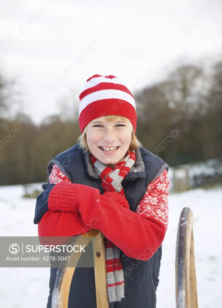 Portrait of a boy leaning on a sled