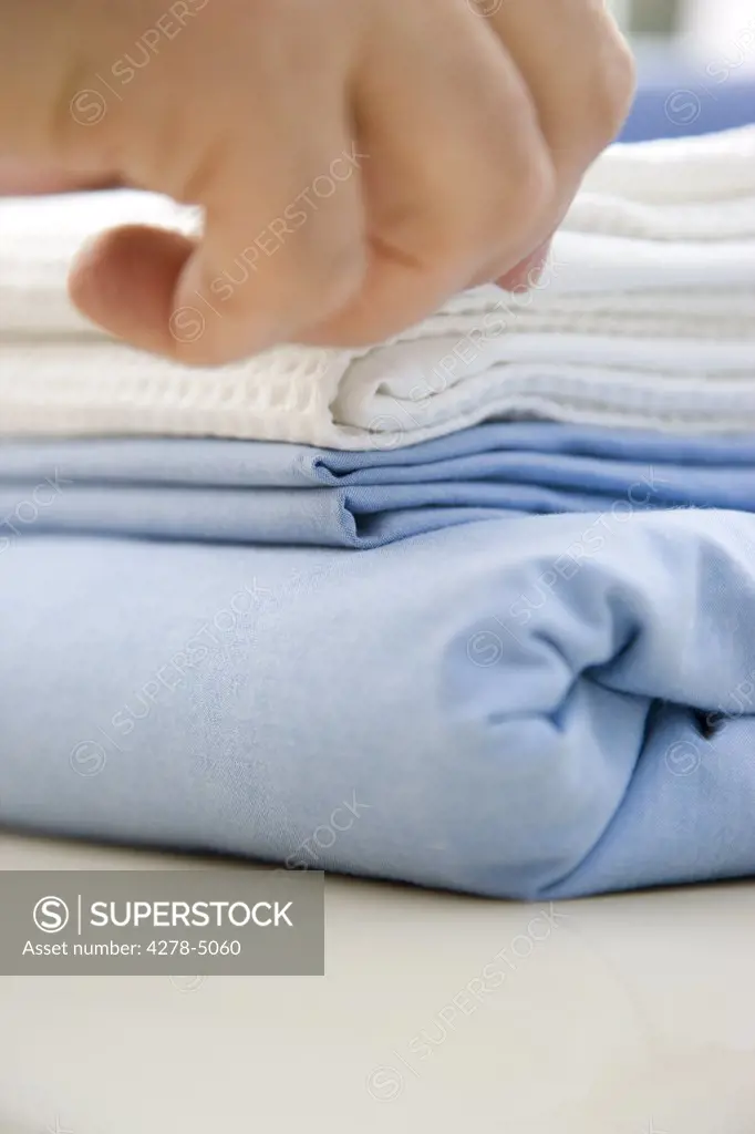 Close up of a man hand folding bed linen
