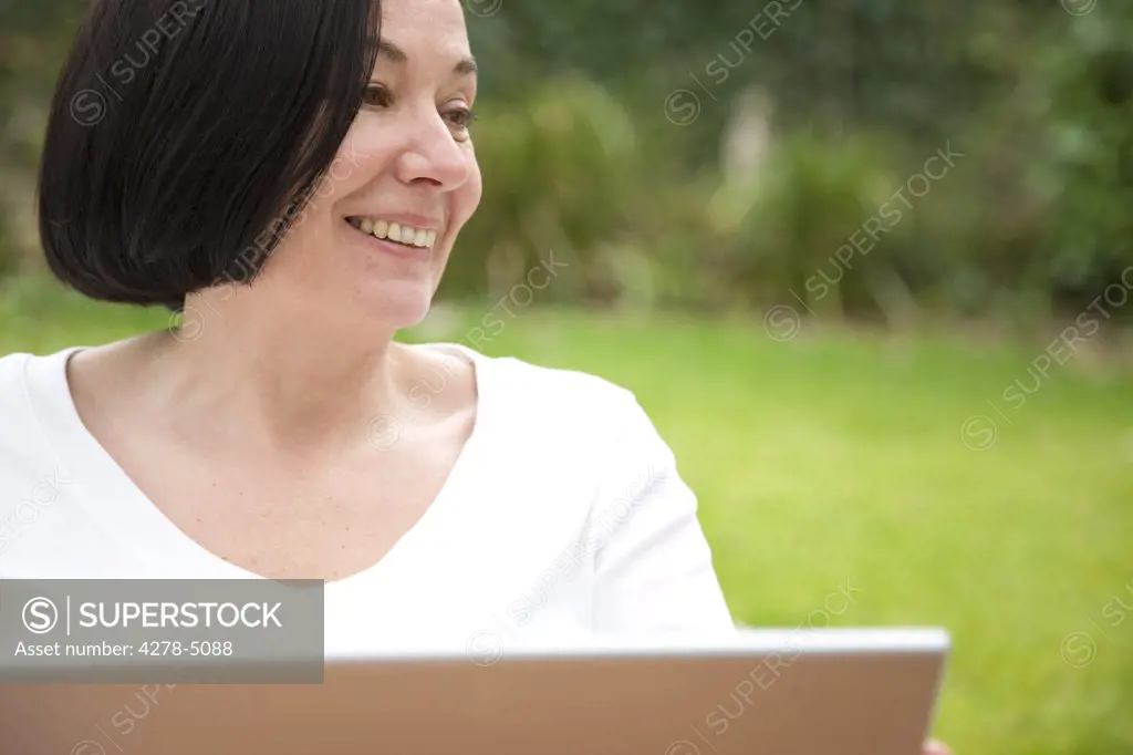 Smiling woman using a laptop computer