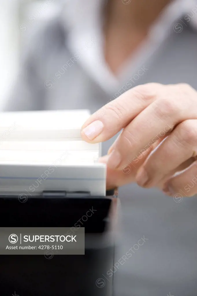 Close up of a woman hand flicking through contact cards