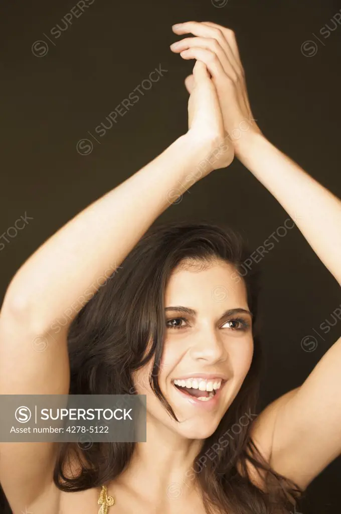 Woman dancing and clapping her hands above her head