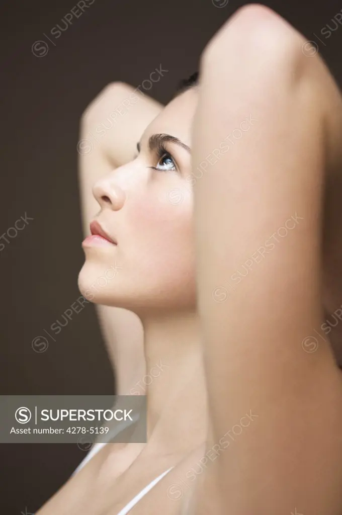 Profile of a woman with her arms crossed behind her head