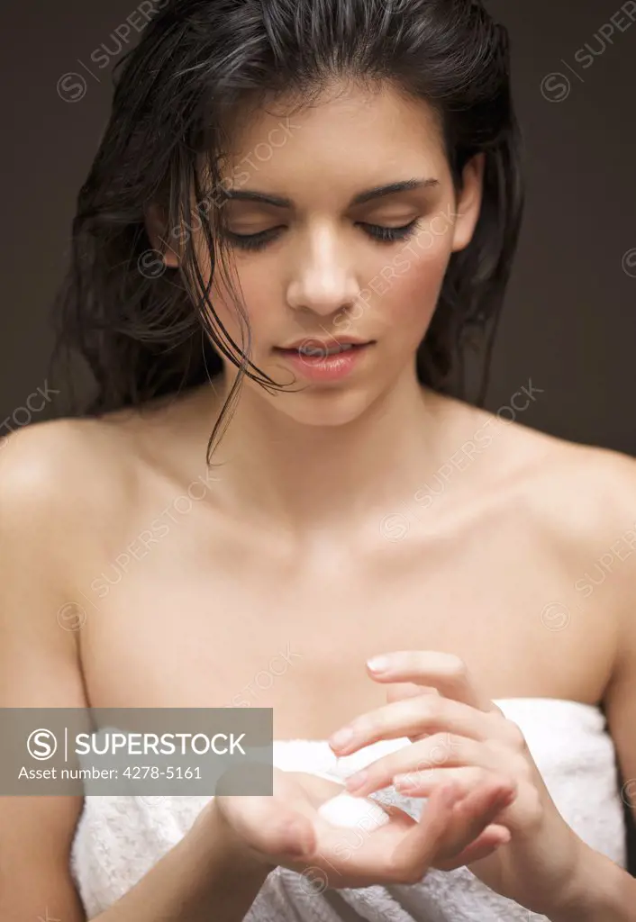 Woman with moisturizing cream in the palm of her hand