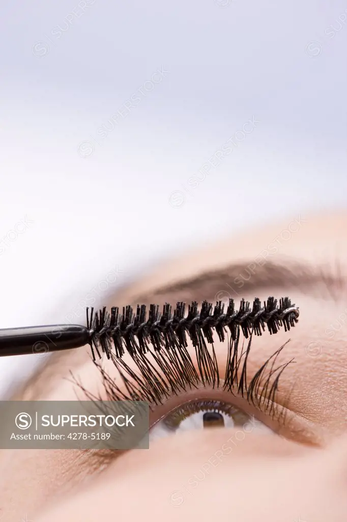Extreme close up of a woman eye with mascara brush