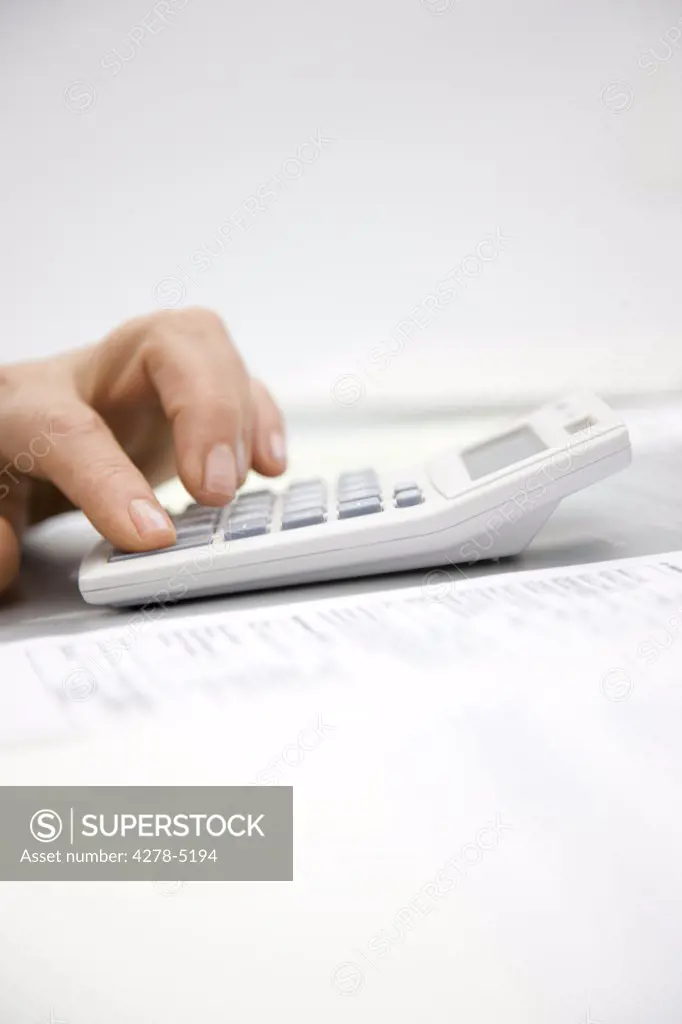 Close up of a woman hand pressing a calculator key