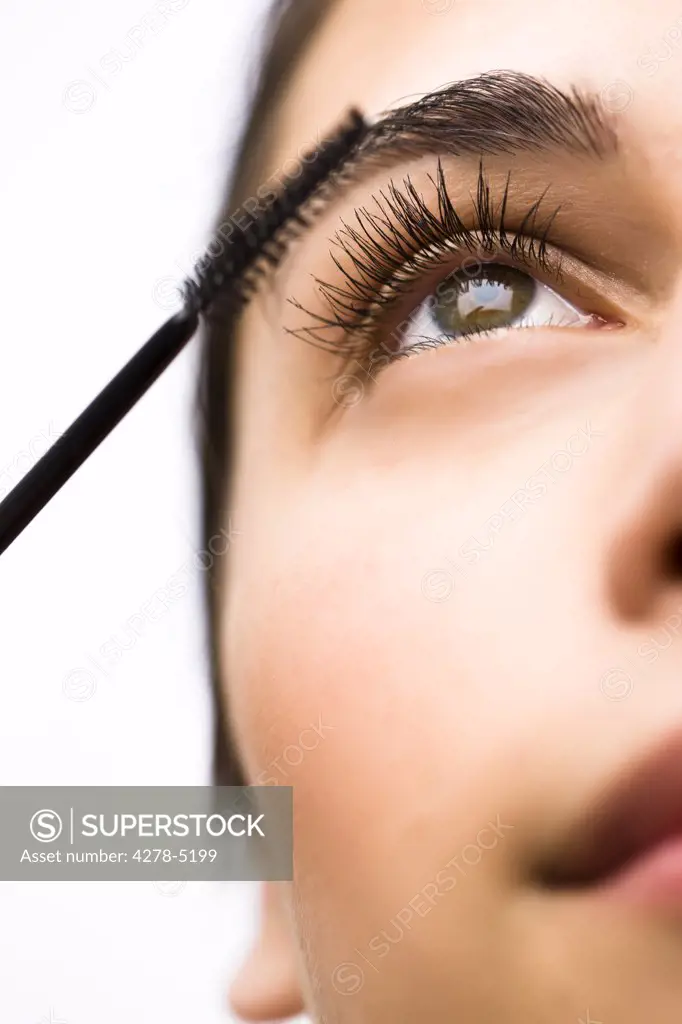 Extreme close up of a woman applying mascara