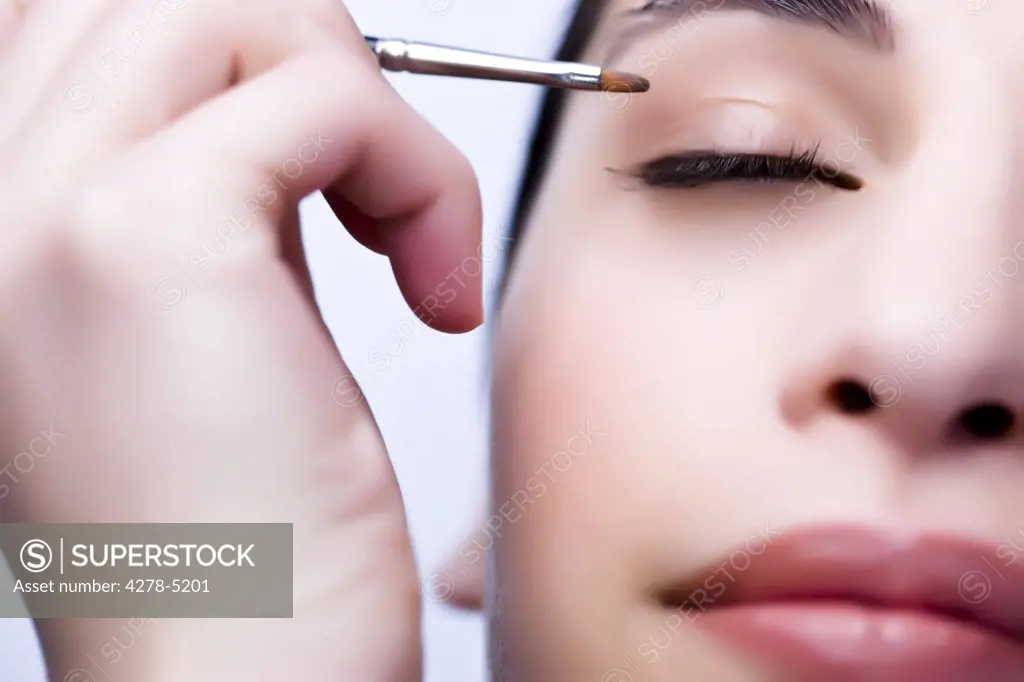 Extreme close up of a woman applying eyeshadow