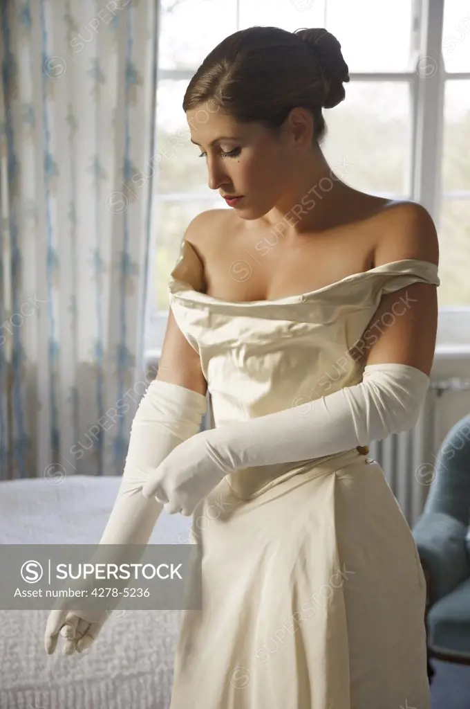 Bride in white wedding gown adjusting her glove