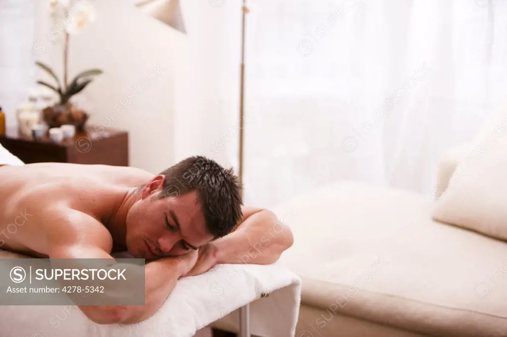 Man lying on his stomach on a treatment bench