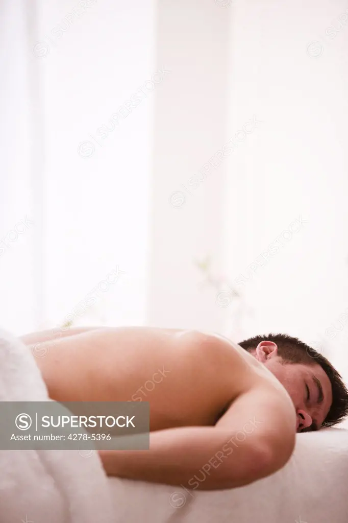 Man lying on his stomach on a treatment bench