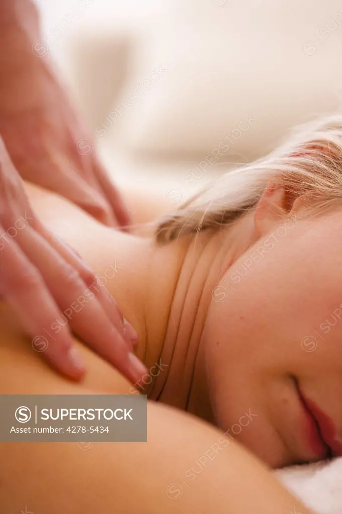 Close up of a masseur hands giving a woman a massage