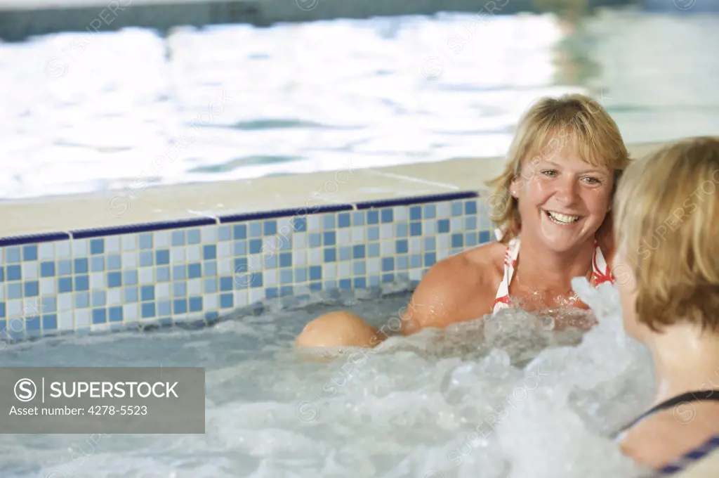 Two women having hydrotherapy and talking