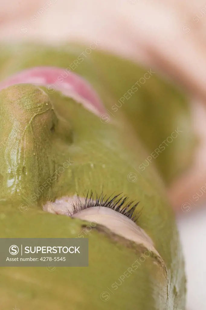 Extreme close up of a woman with green facial mask - upside down