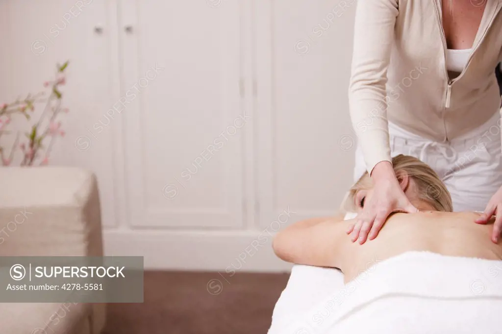 Masseuse giving a woman a back massage