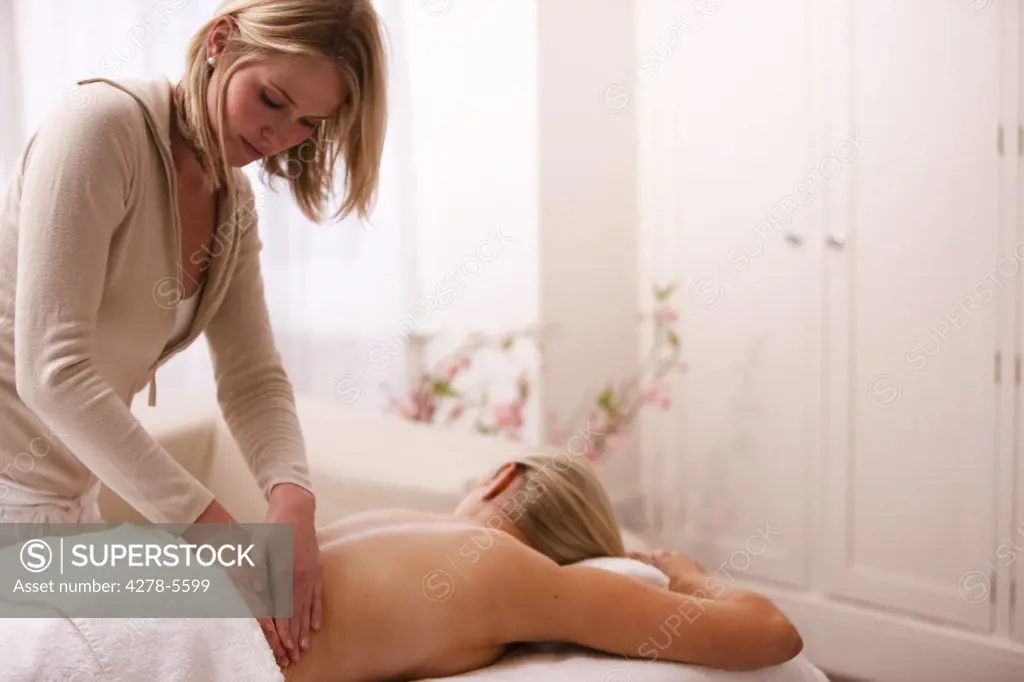 Masseuse giving a woman a back massage