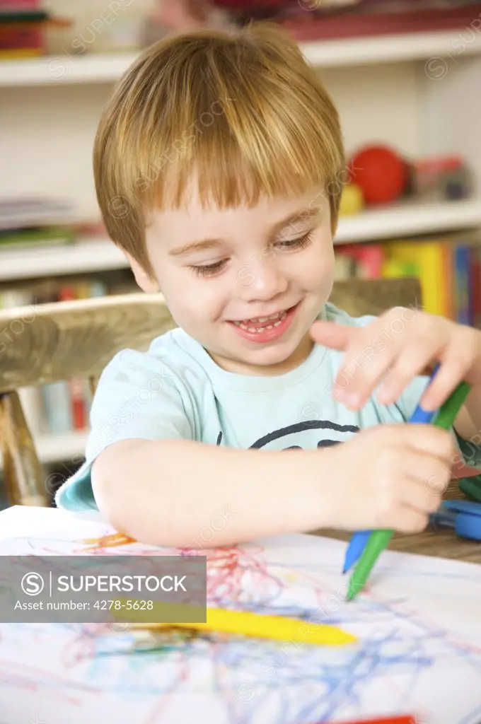 Smiling boy drawing and coloring