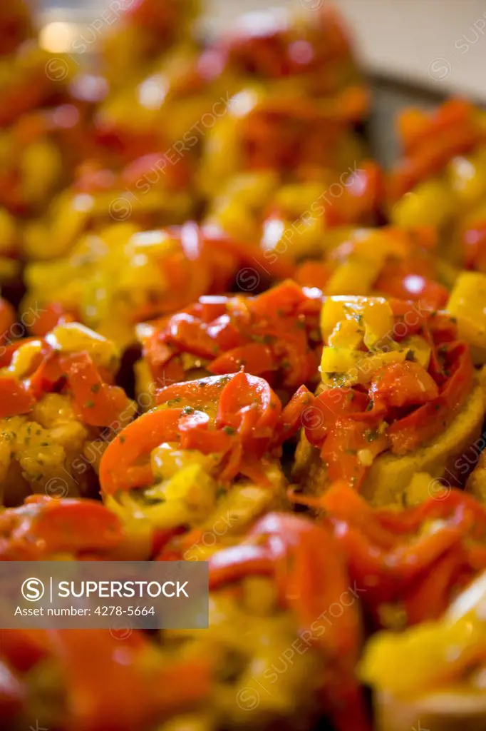 Close up of red and yellow peppers crostini