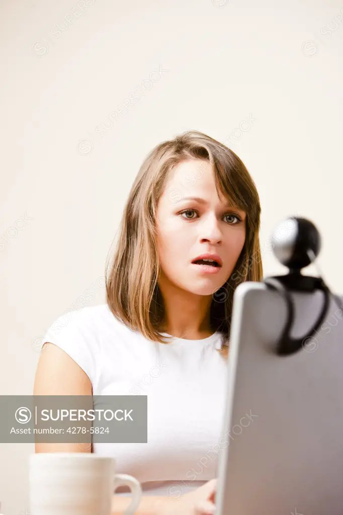 Woman using laptop computer with web cam