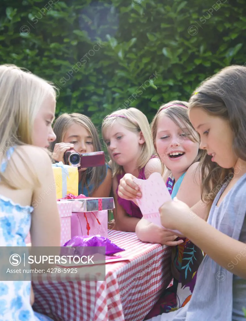 Young girl sitting with friends reading a birthday card