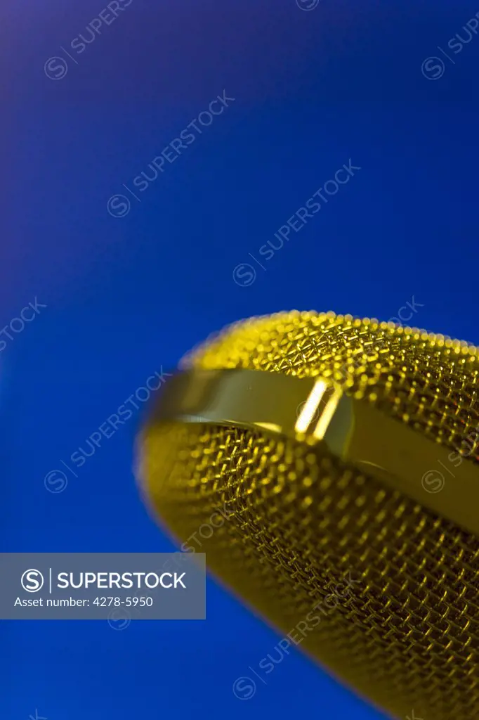 Extreme close up of a gold microphone