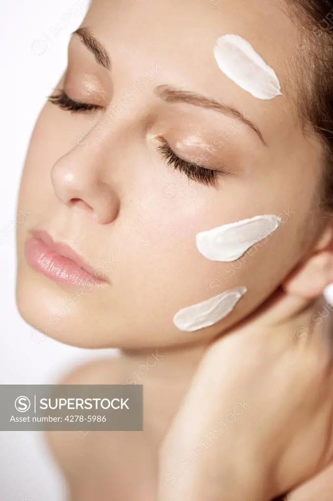 Close up of a young woman with moisturizing cream on her face