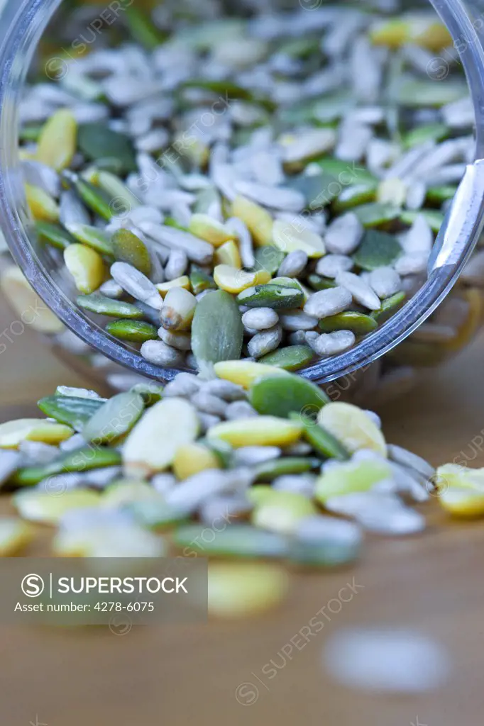 Close up of mixed seeds spilling out of a container