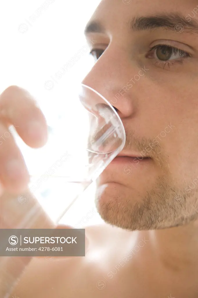Close up of a young man drinking water