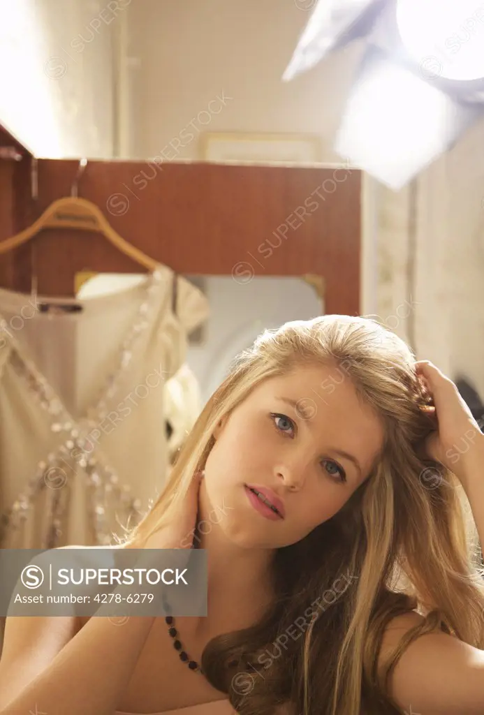 Young woman touching her hair under spotlight