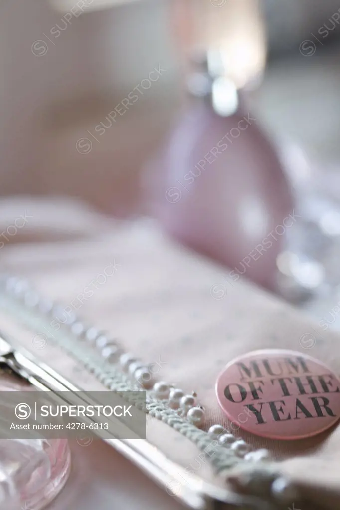 Detail of a clutch bag with a 'mum of the year' badge