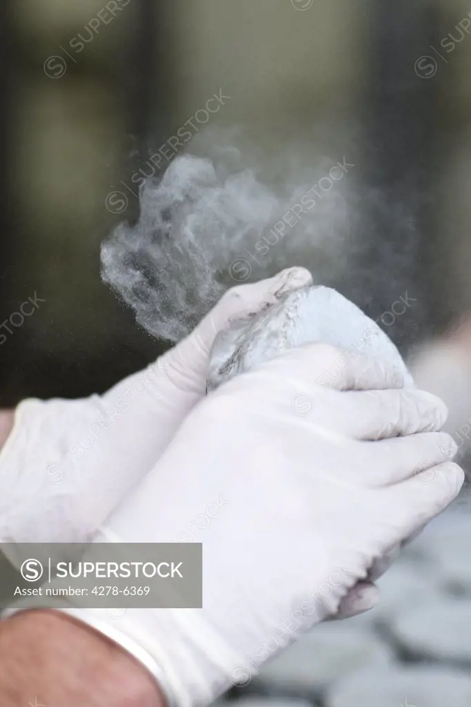 Close up of a man's hands cleaning cheese